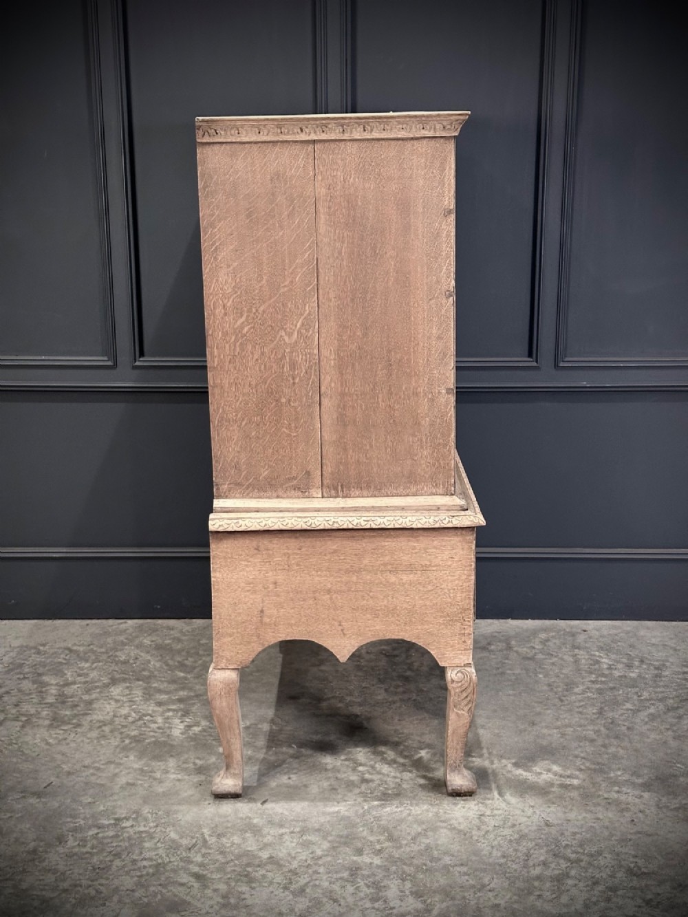 An 18th-century bleached oak chest on stand featuring carved foliage motifs across the drawer fronts and elevated on cabriole legs. View X