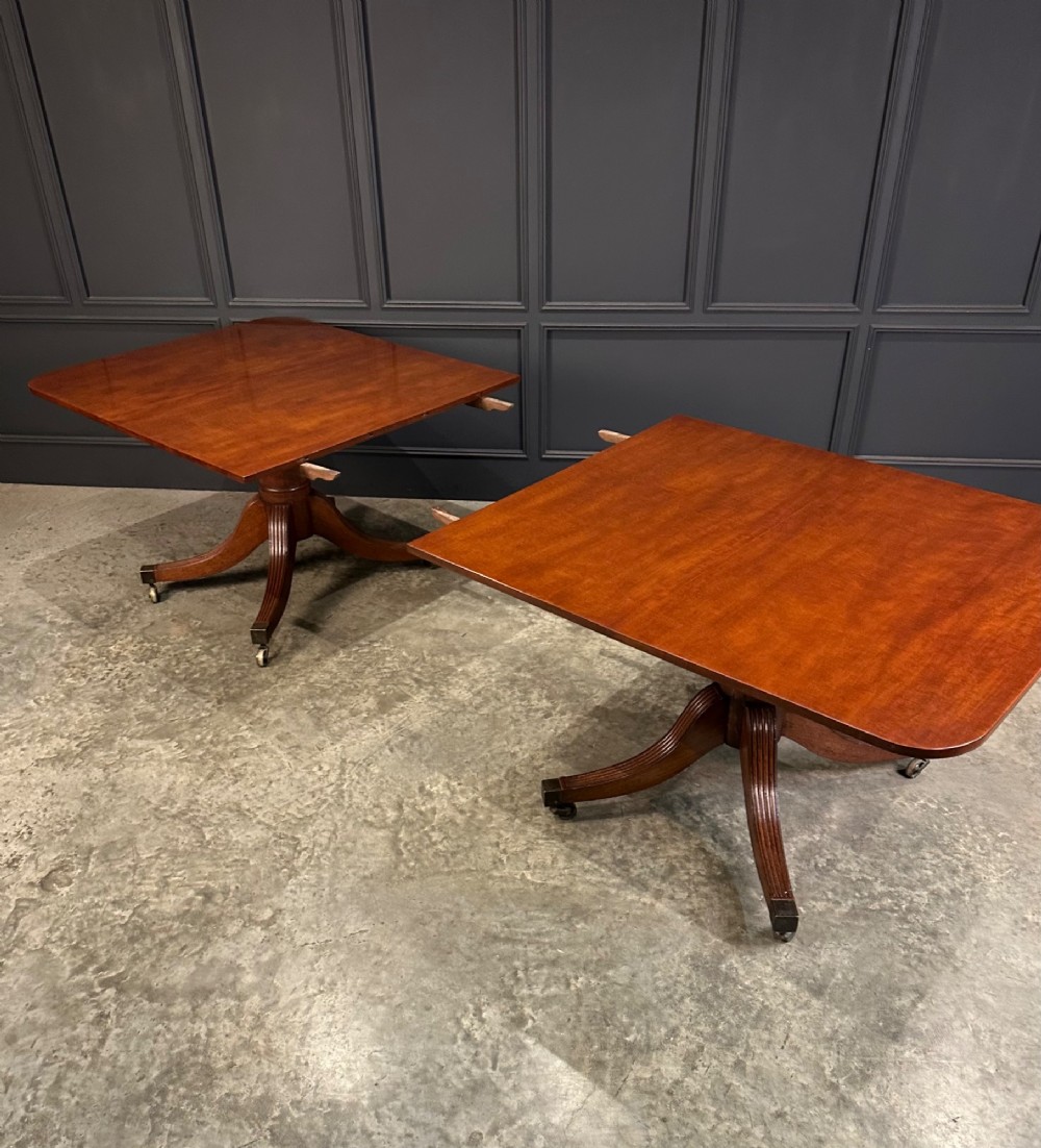 An extended mahogany twin pillar dining table with reeded splayed legs and brass castors. View V