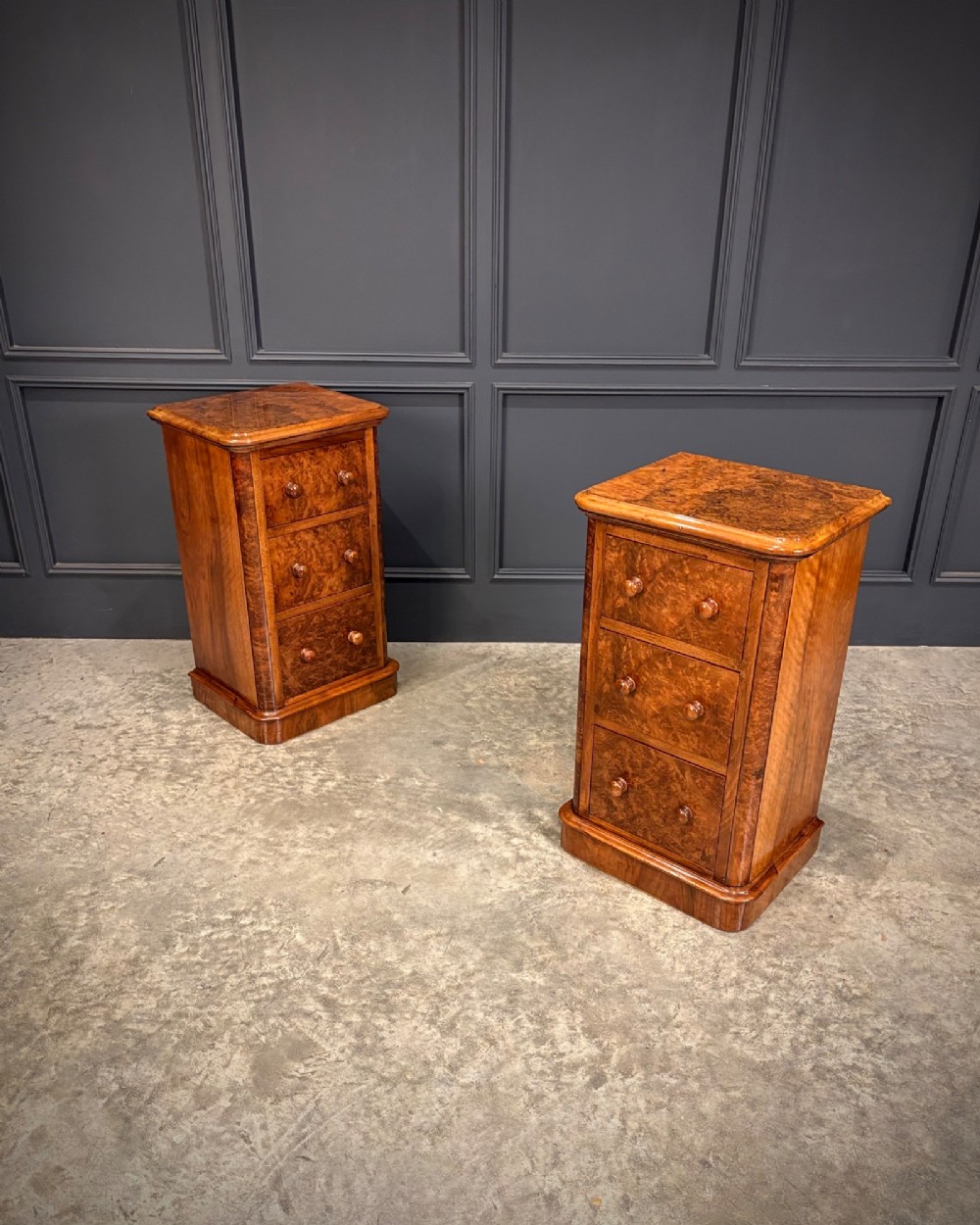 A matching pair of Victorian burr walnut bedside chests featuring three drawers each with turned wooden knobs and rounded plinth bases. View III