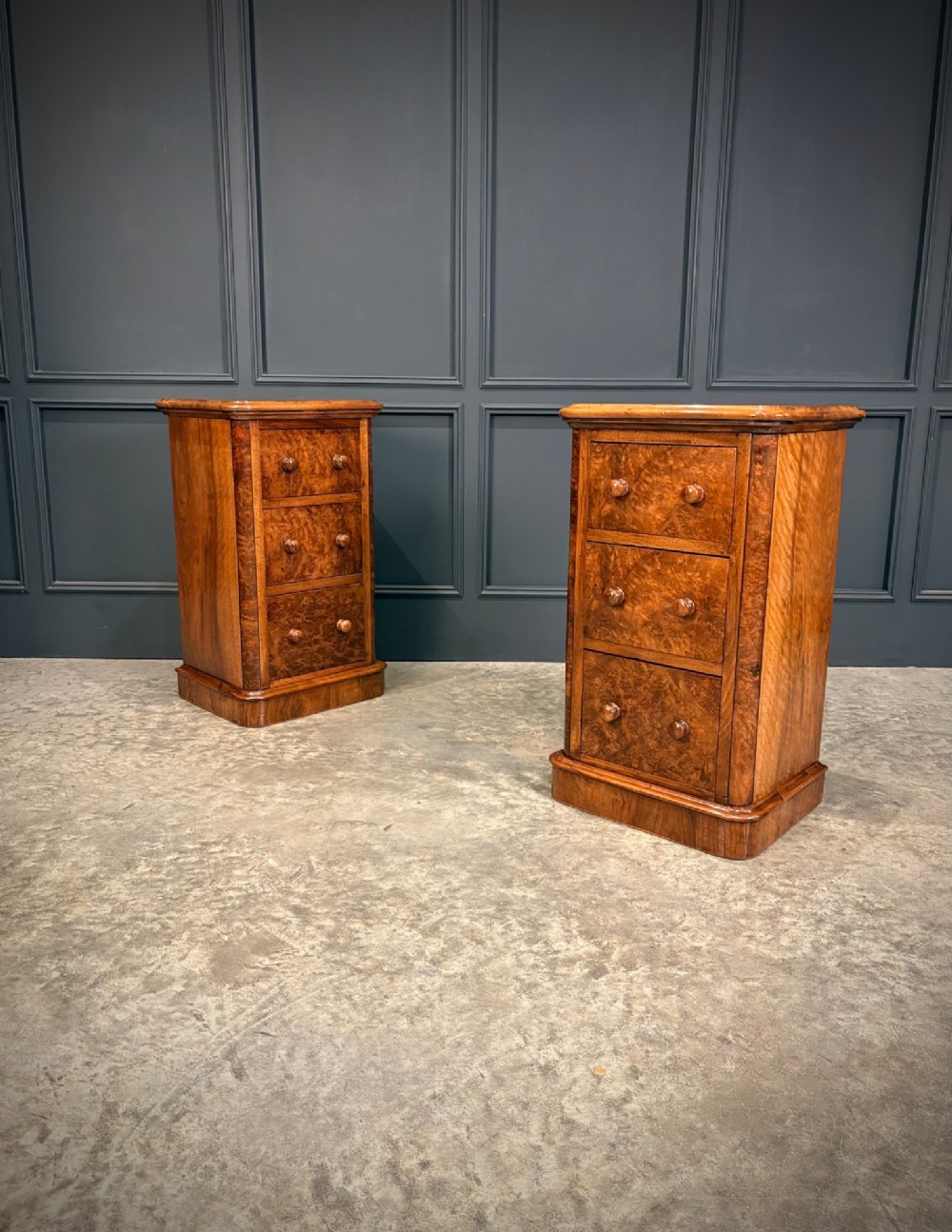 A matching pair of Victorian burr walnut bedside chests featuring three drawers each with turned wooden knobs and rounded plinth bases. View IV