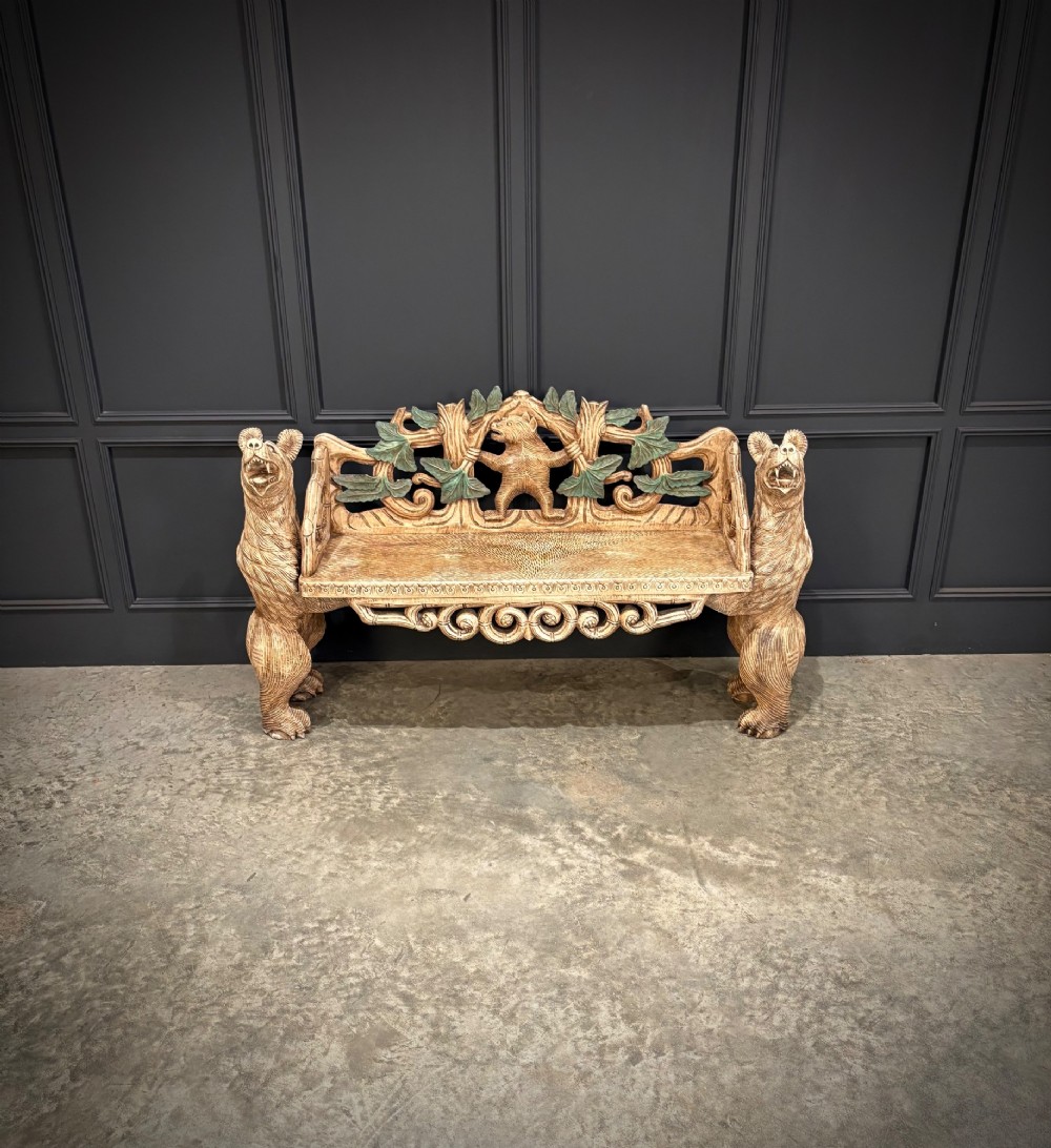 A carved wooden two-seat bench featuring two rearing bears forming the sides and armrests, with scroll motifs and carved green foliage across the backrest. View III