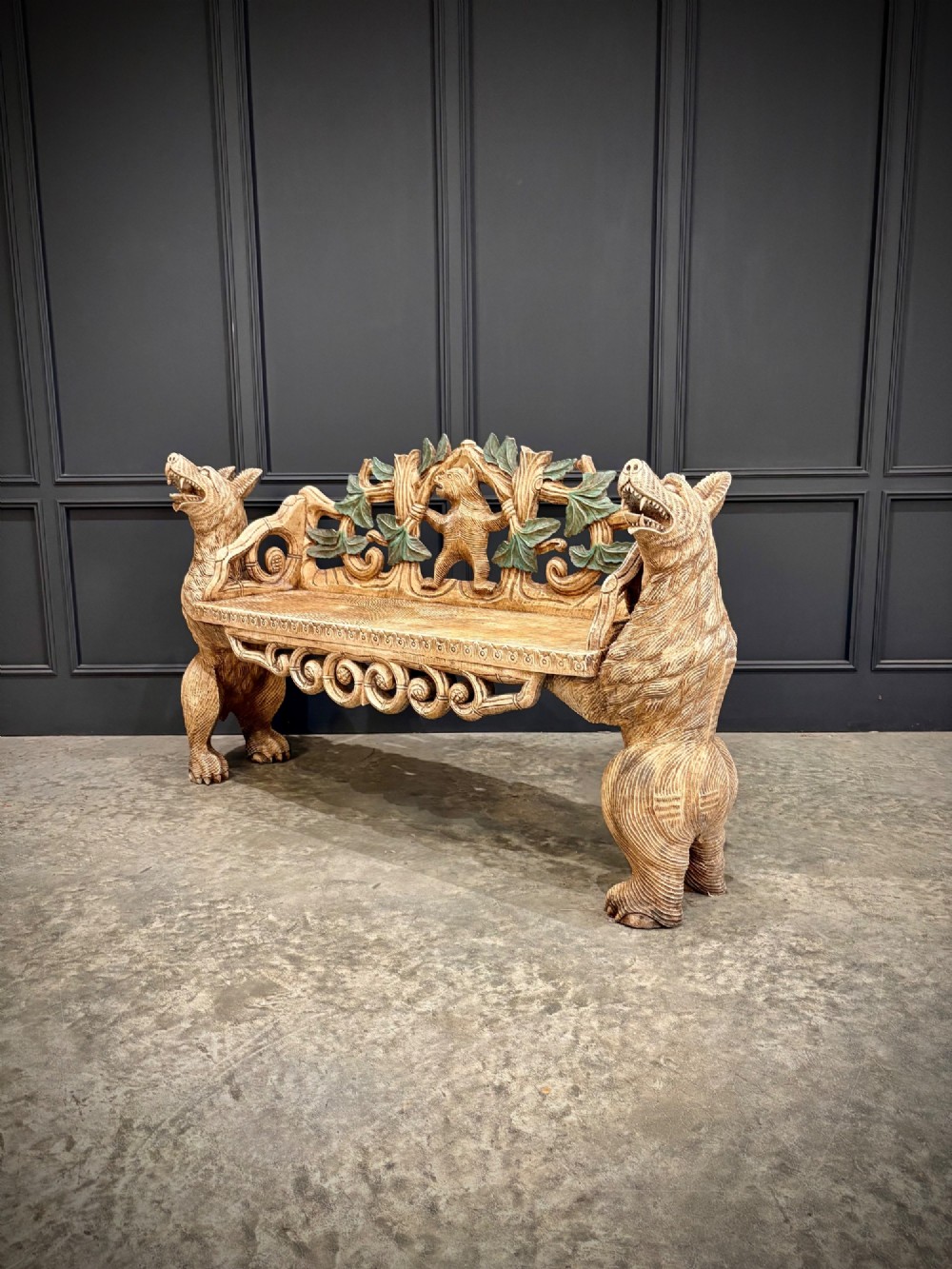 A carved wooden two-seat bench featuring two rearing bears forming the sides and armrests, with scroll motifs and carved green foliage across the backrest. View VI