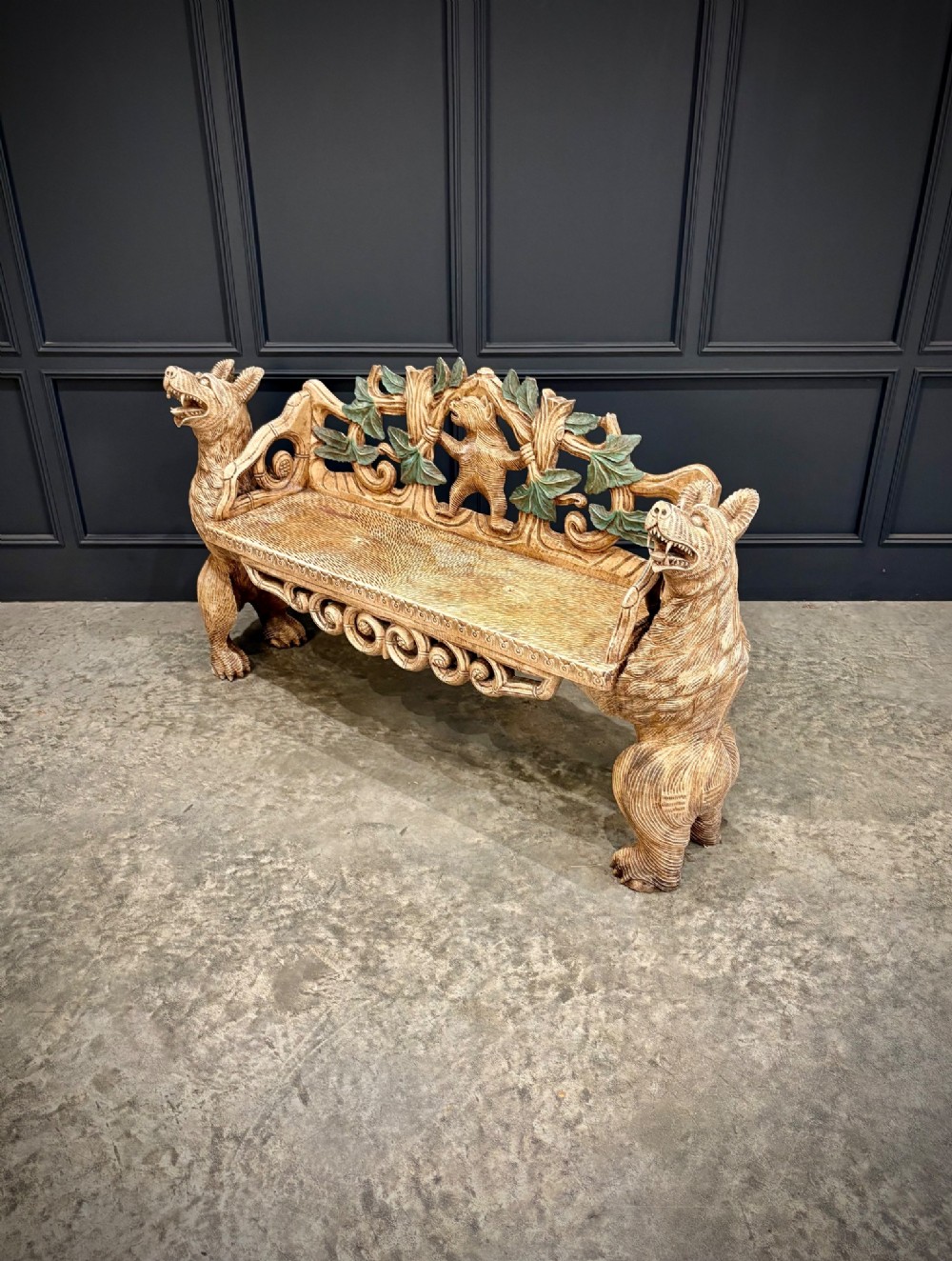 A carved wooden two-seat bench featuring two rearing bears forming the sides and armrests, with scroll motifs and carved green foliage across the backrest. View VII