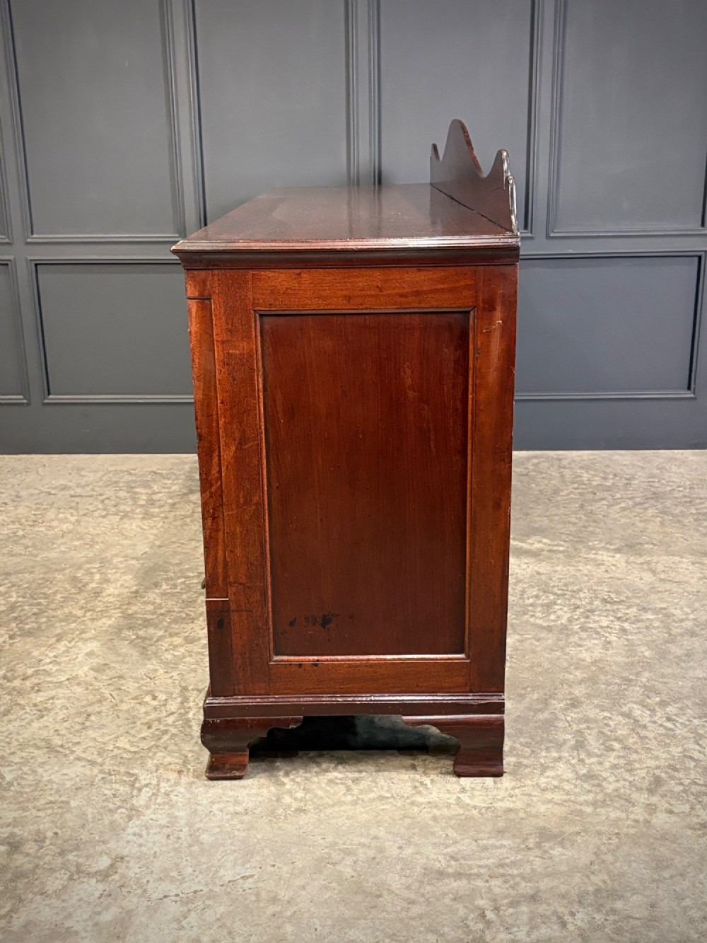 An 18th-century mahogany bank of nine drawers featuring a shaped upstand gallery back, brass swan-neck handles, and bracket feet. View VIII