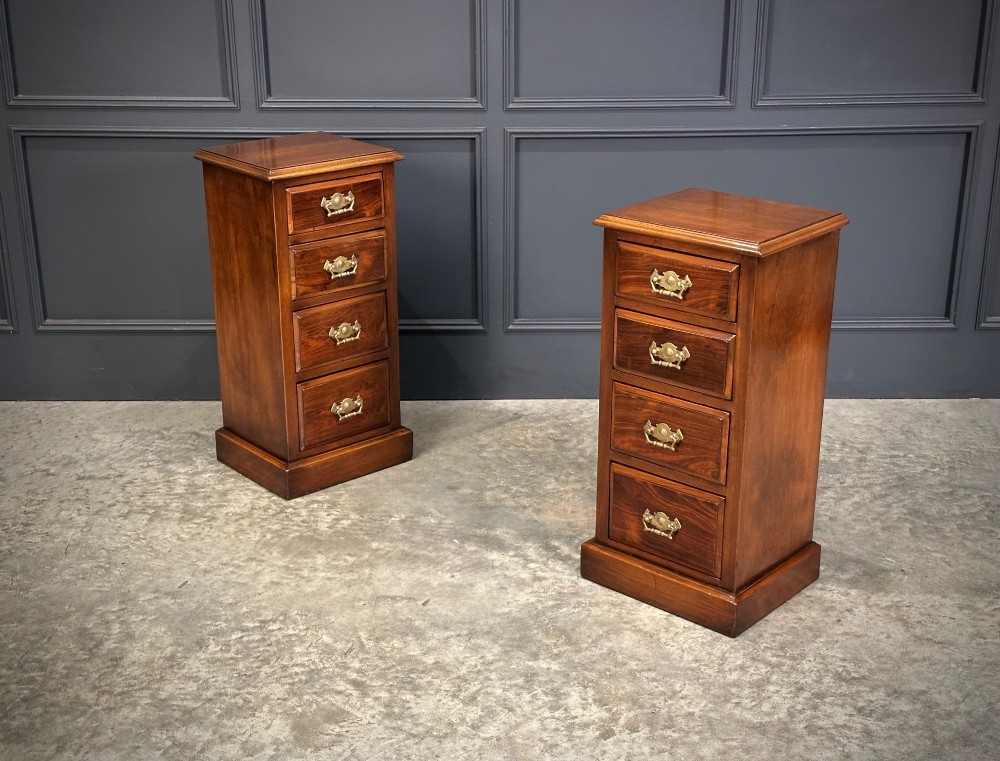 A pair of tall Edwardian mahogany and rosewood four-drawer bedside chests with brass drop handles and plinth bases. View II