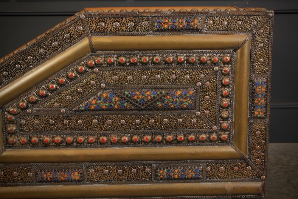 A boxy Moroccan-style sofa featuring tan leather upholstery on the seat and interior, surrounded by an exterior clad in embossed brass metal panels with decorative studding. View IX