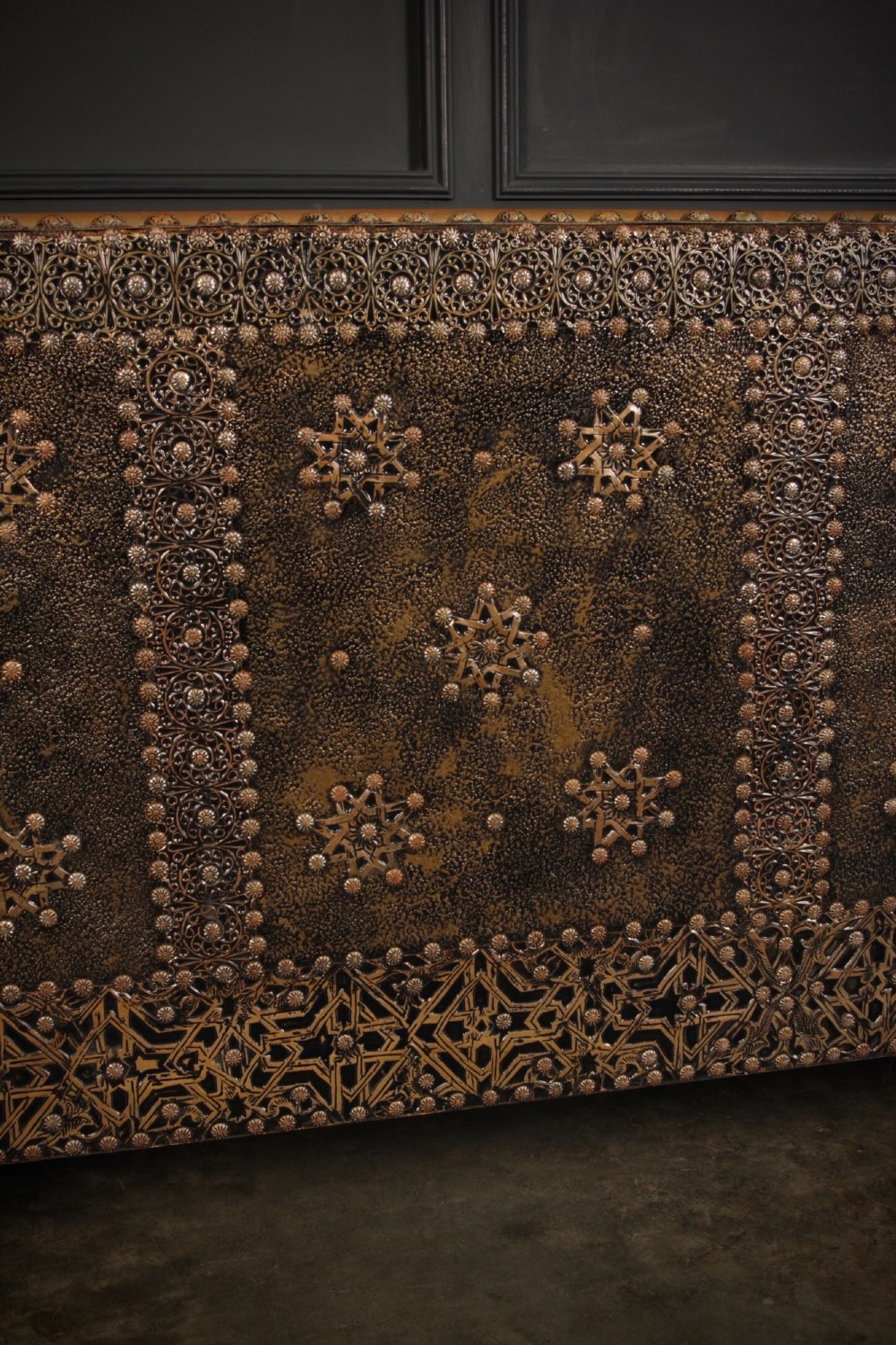 A boxy Moroccan-style sofa featuring tan leather upholstery on the seat and interior, surrounded by an exterior clad in embossed brass metal panels with decorative studding. View XI
