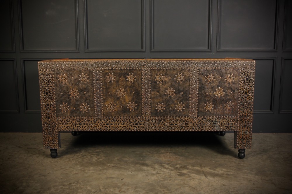 A boxy Moroccan-style sofa featuring tan leather upholstery on the seat and interior, surrounded by an exterior clad in embossed brass metal panels with decorative studding. View XII