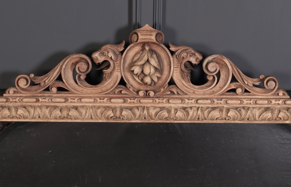 A wide Victorian oak overmantel mirror featuring detailed hand-carved cresting with beast heads, side pilasters with fruit swags, and carved human masks. View III