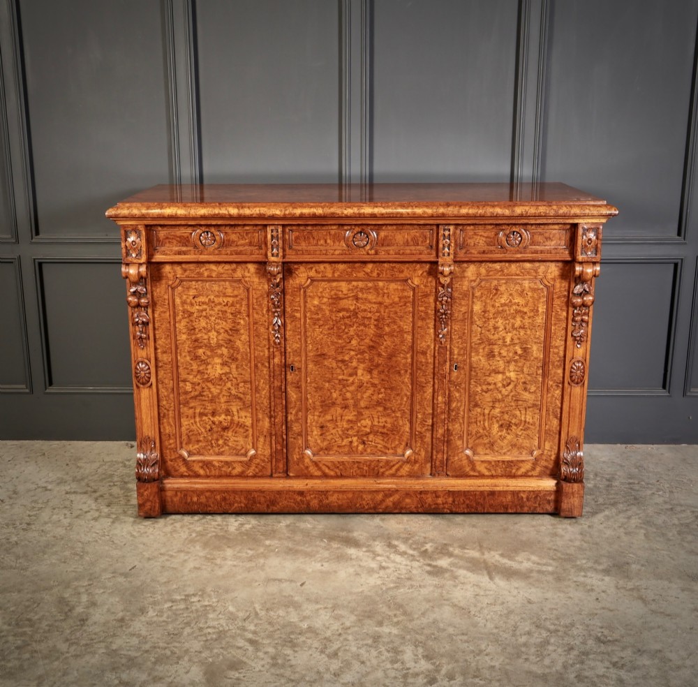 A 19th-century Victorian pollard oak sideboard featuring three relief-panelled cupboard doors, carved corbels, and a figure-rich timber surface. View IV