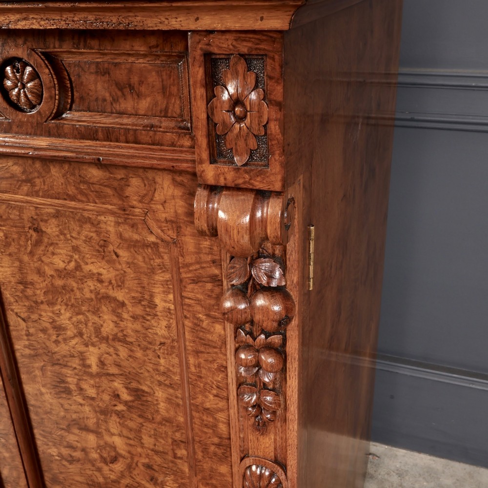 A 19th-century Victorian pollard oak sideboard featuring three relief-panelled cupboard doors, carved corbels, and a figure-rich timber surface. View IX