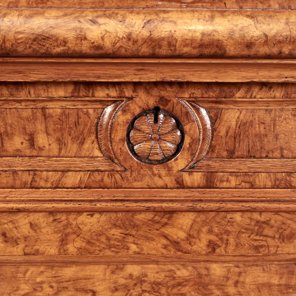 A 19th-century Victorian pollard oak sideboard featuring three relief-panelled cupboard doors, carved corbels, and a figure-rich timber surface. View X