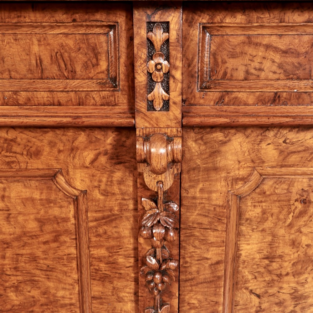 A 19th-century Victorian pollard oak sideboard featuring three relief-panelled cupboard doors, carved corbels, and a figure-rich timber surface. View XI