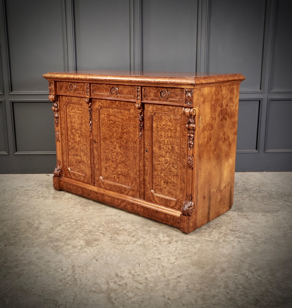 A 19th-century Victorian pollard oak sideboard featuring three relief-panelled cupboard doors, carved corbels, and a figure-rich timber surface. View XII