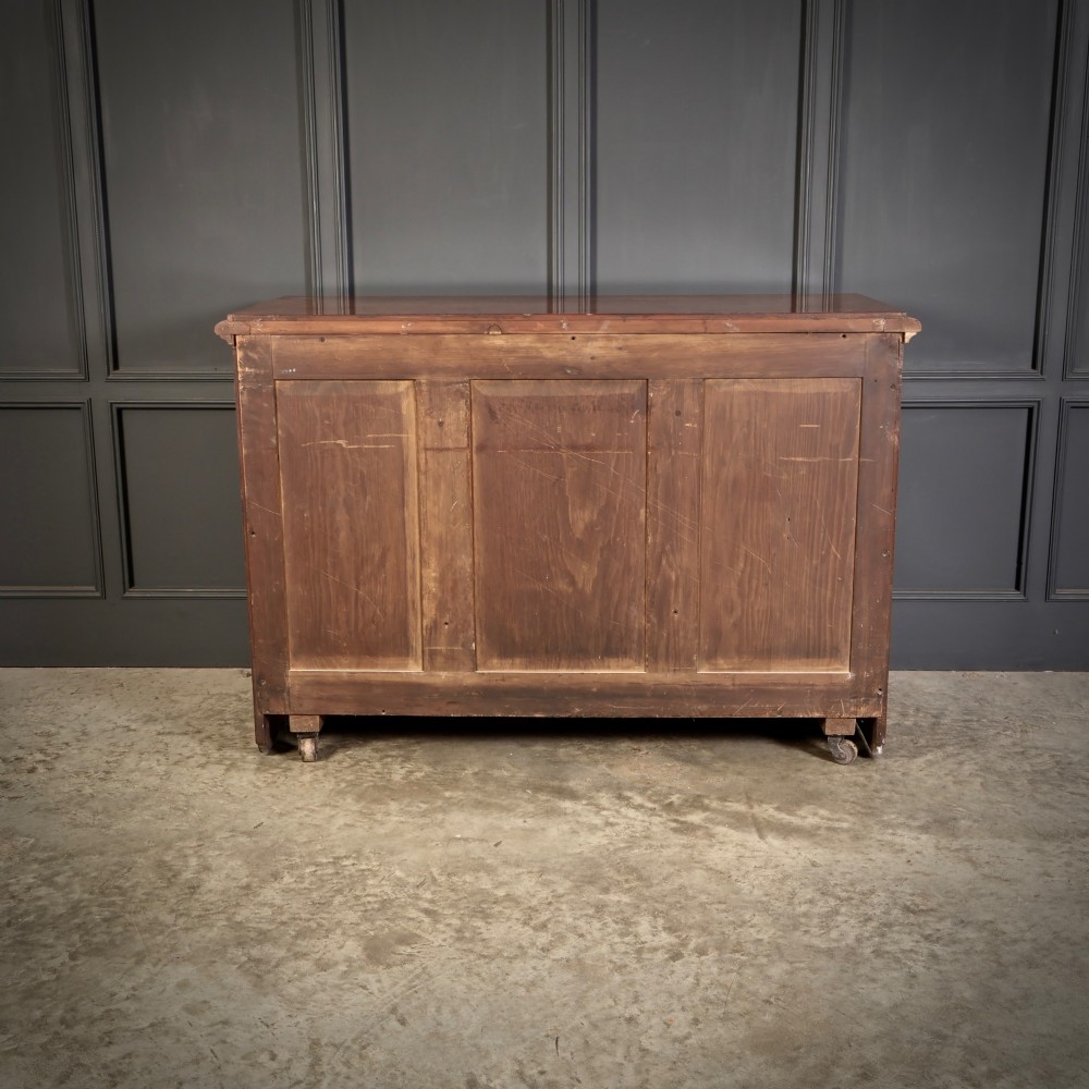 A 19th-century Victorian pollard oak sideboard featuring three relief-panelled cupboard doors, carved corbels, and a figure-rich timber surface. View XIV