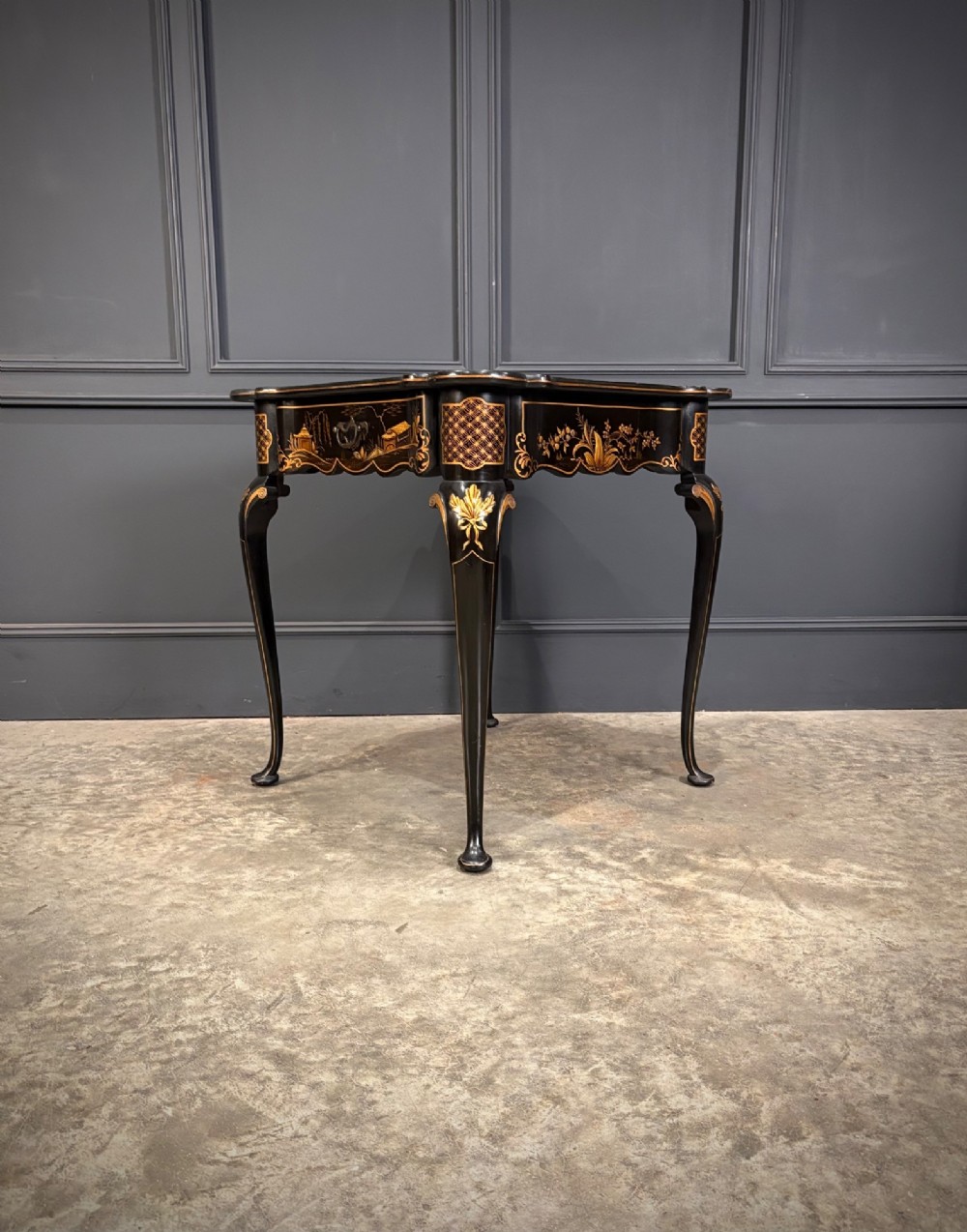 A black lacquered square occasional table featuring gilded Chinoiserie landscape scenes, shaped apron edges, a single drawer, and slender cabriole legs. View III