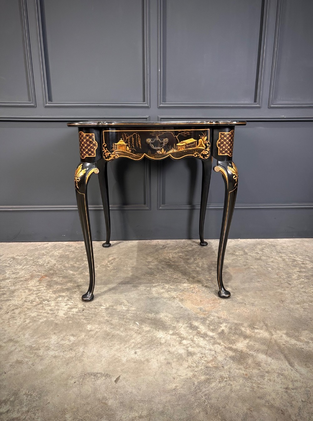 A black lacquered square occasional table featuring gilded Chinoiserie landscape scenes, shaped apron edges, a single drawer, and slender cabriole legs. View VI