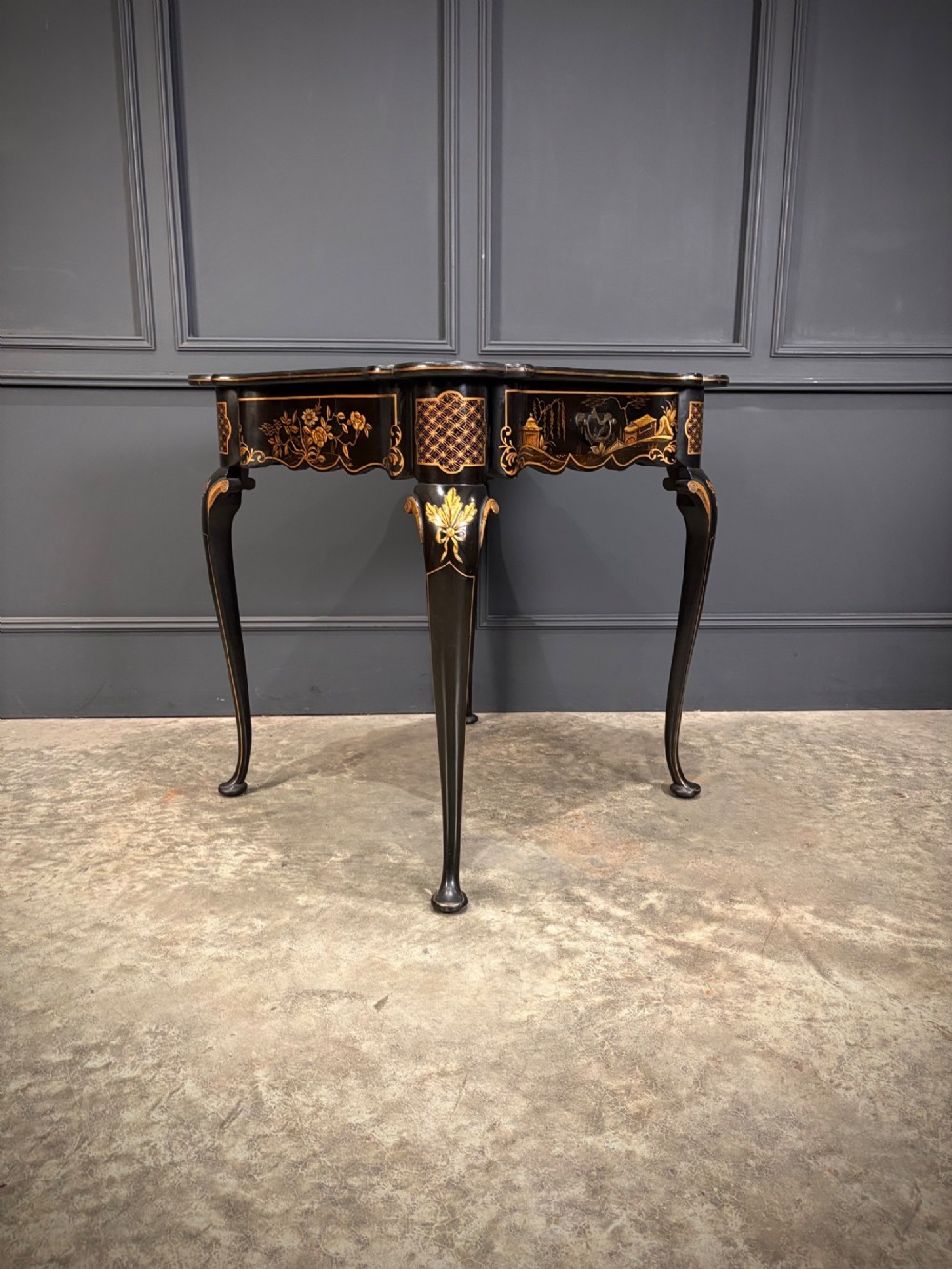 A black lacquered square occasional table featuring gilded Chinoiserie landscape scenes, shaped apron edges, a single drawer, and slender cabriole legs. View VII