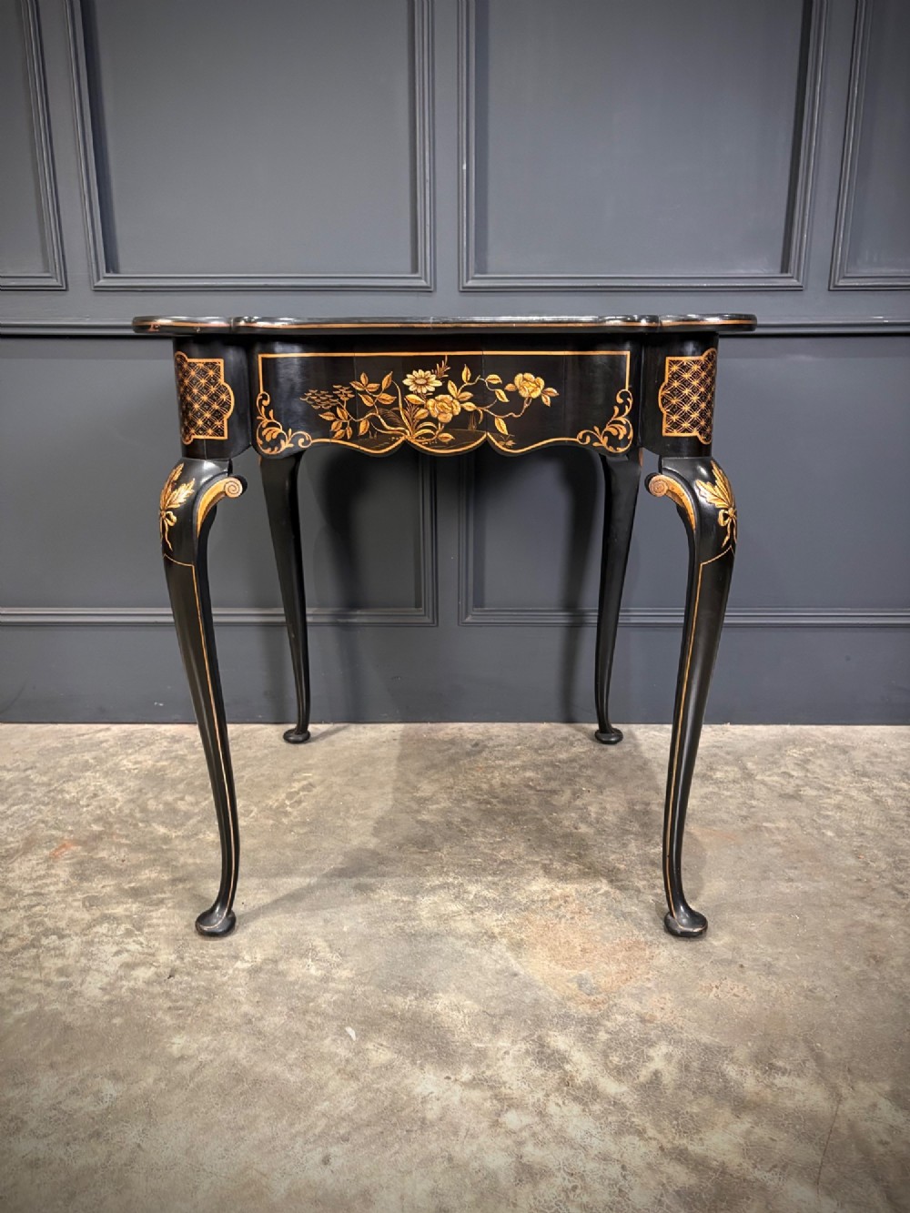 A black lacquered square occasional table featuring gilded Chinoiserie landscape scenes, shaped apron edges, a single drawer, and slender cabriole legs. View XI