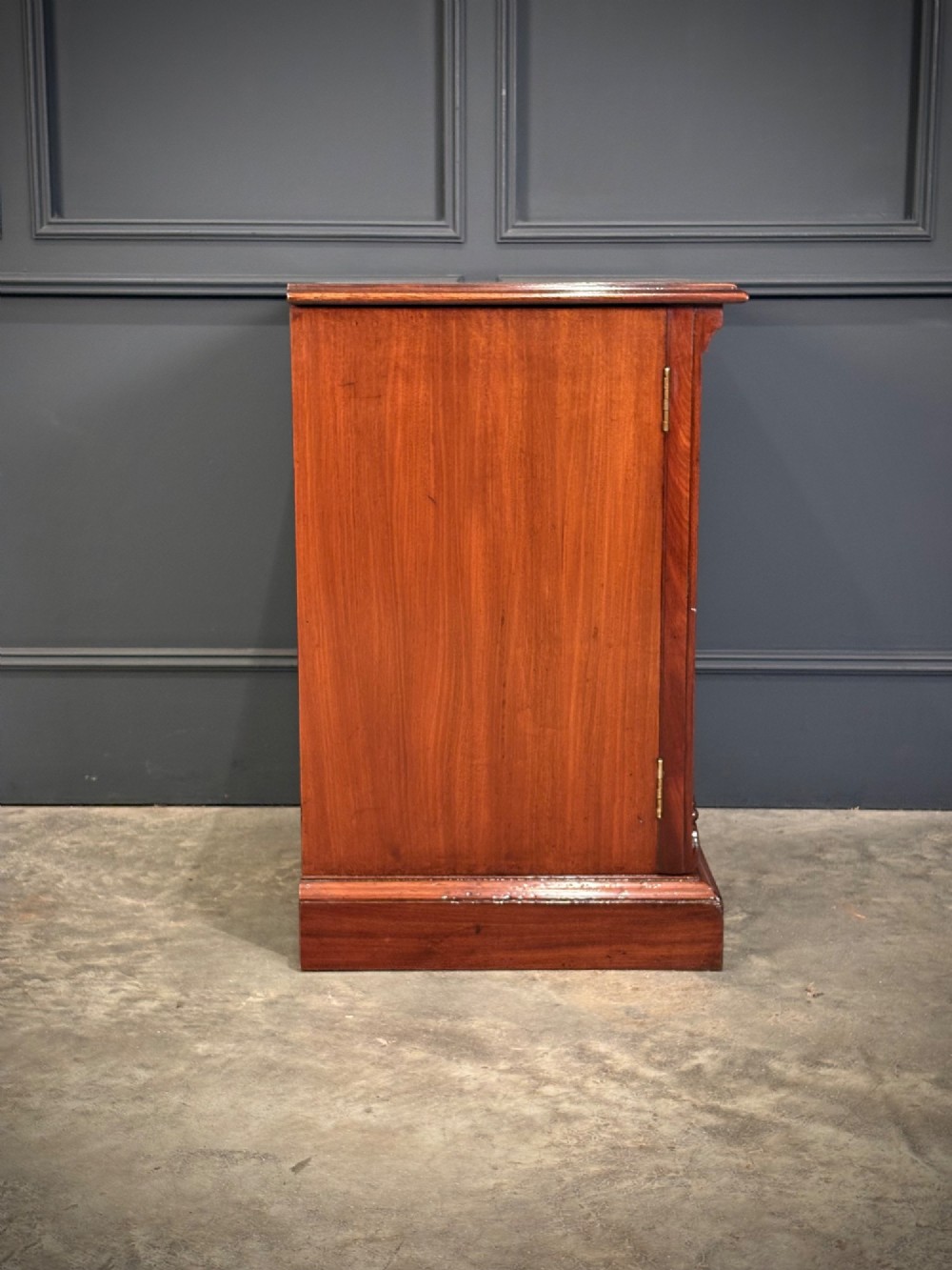 A matching pair of Victorian mahogany bedside cabinets featuring panelled doors with flame veneer and carved fluted pilasters on plinth bases. View X