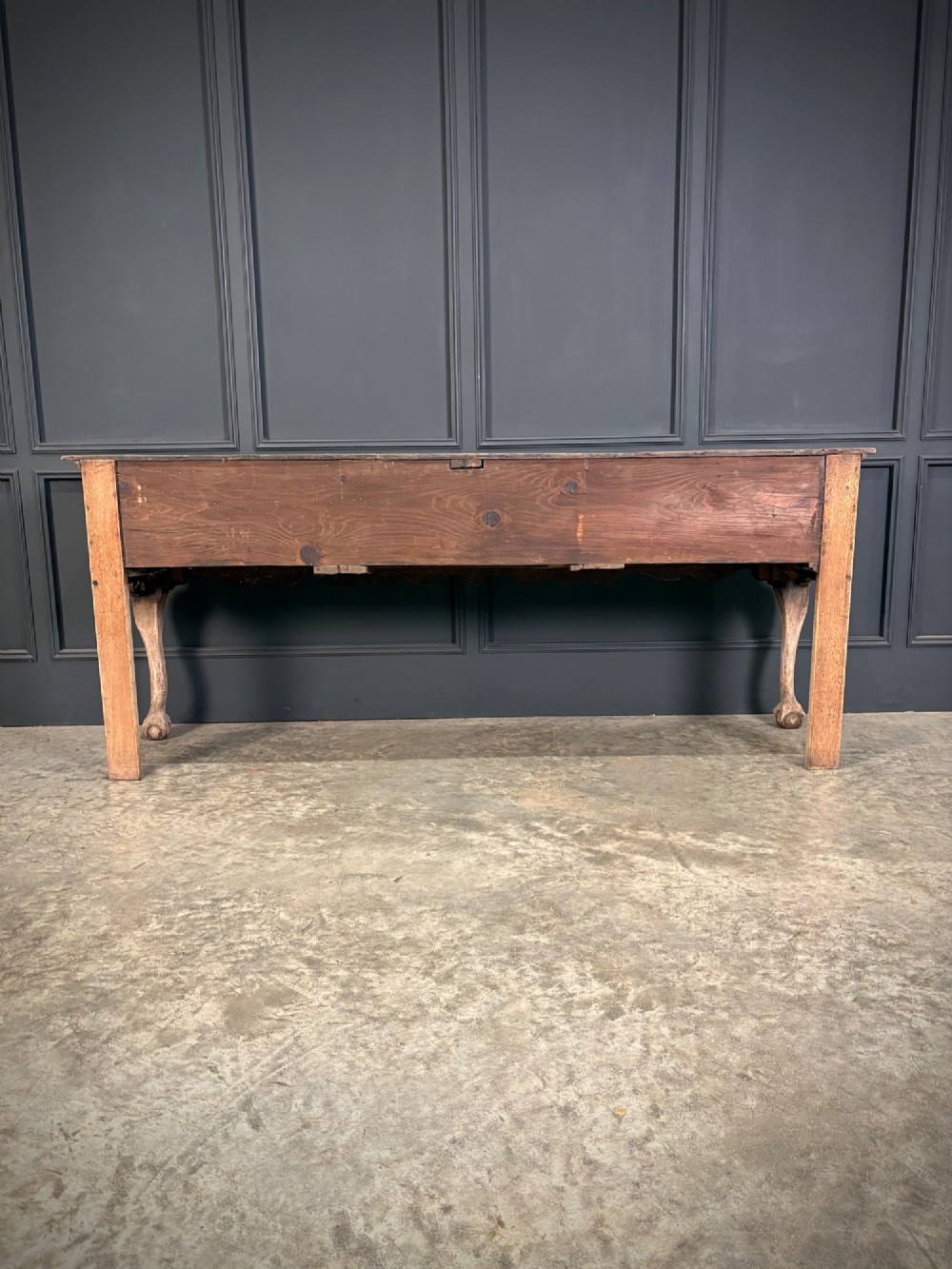 An 18th-century carved oak dresser base with three carved drawer fronts, a decorative apron, cabriole front legs, and claw and ball feet. View X