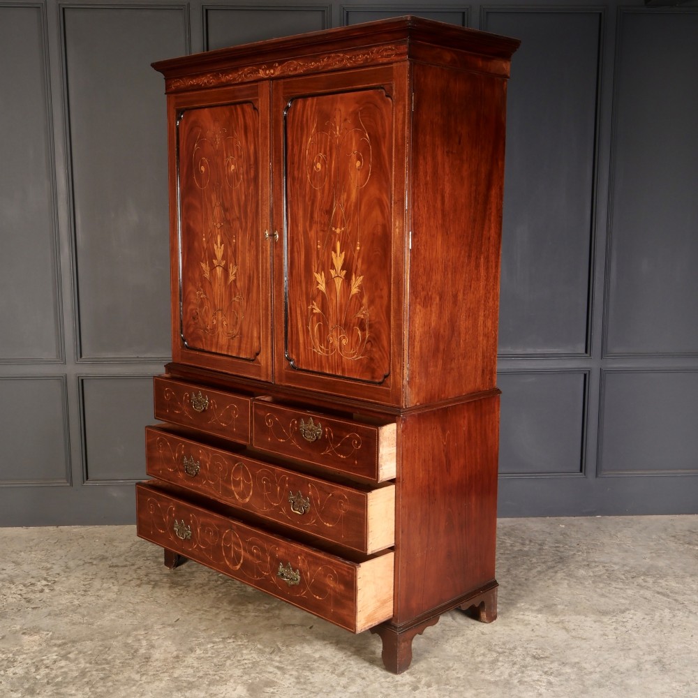 An antique Georgian mahogany gentlemans wardrobe with detailed marquetry inlay on the double doors and lower drawers, standing on bracket feet. View VII