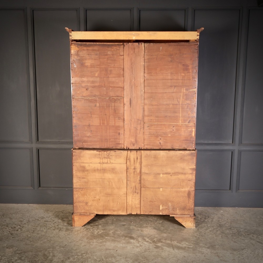 An antique Georgian mahogany gentlemans wardrobe with detailed marquetry inlay on the double doors and lower drawers, standing on bracket feet. View IX