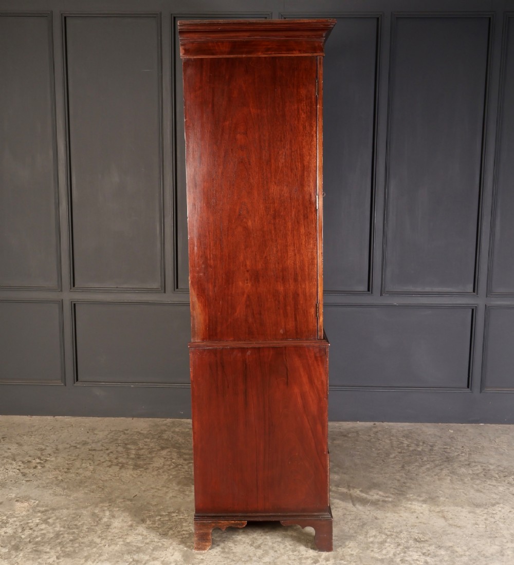 An antique Georgian mahogany gentlemans wardrobe with detailed marquetry inlay on the double doors and lower drawers, standing on bracket feet. View X
