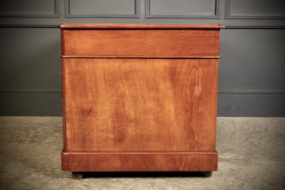 A Victorian walnut pedestal desk featuring a green leather inset top and multiple drawers with brass handles. View IX