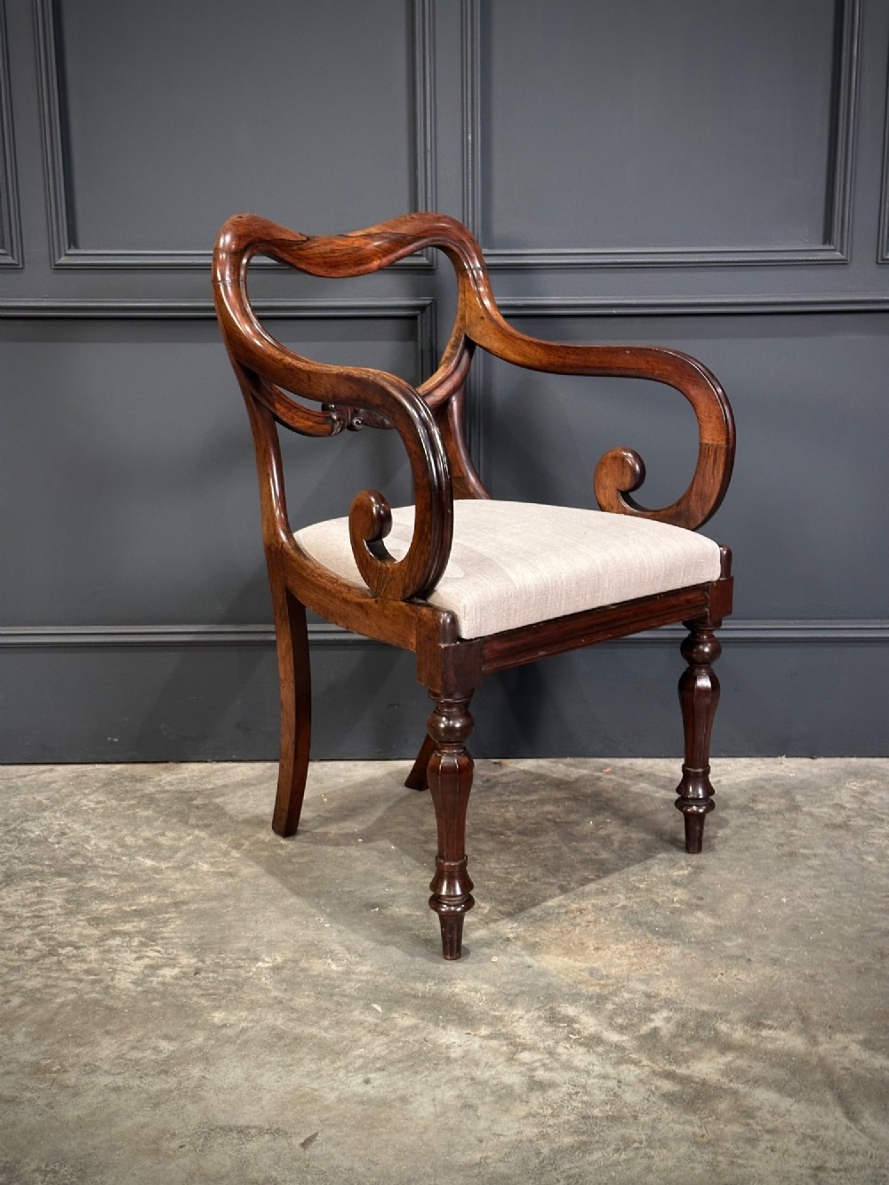 A set of eight Victorian rosewood dining chairs with balloon backs, carved details, scroll armrests, and neutral beige seats. View III