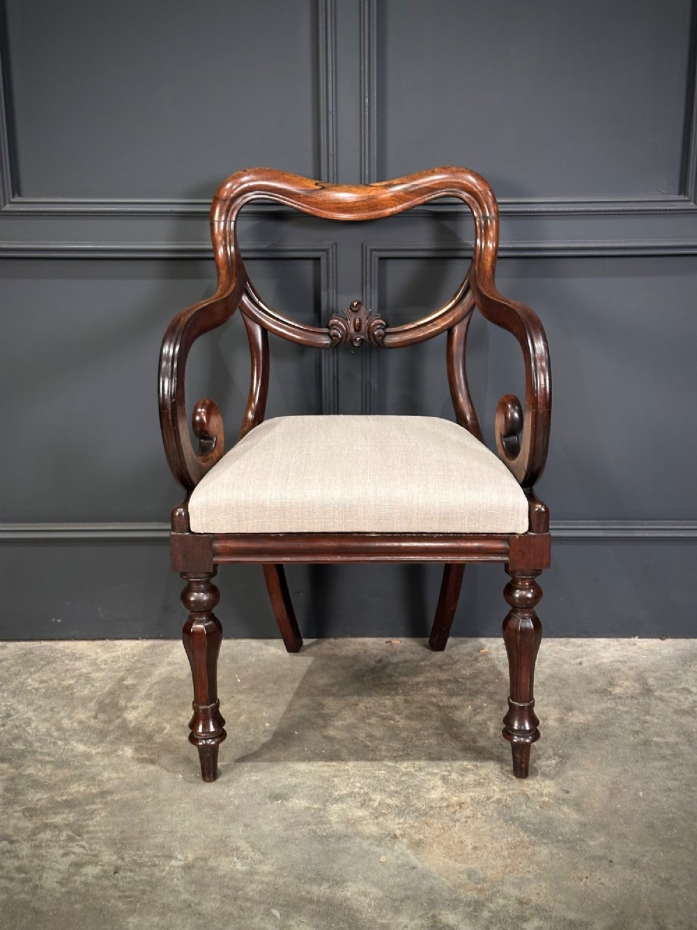A set of eight Victorian rosewood dining chairs with balloon backs, carved details, scroll armrests, and neutral beige seats. View IV