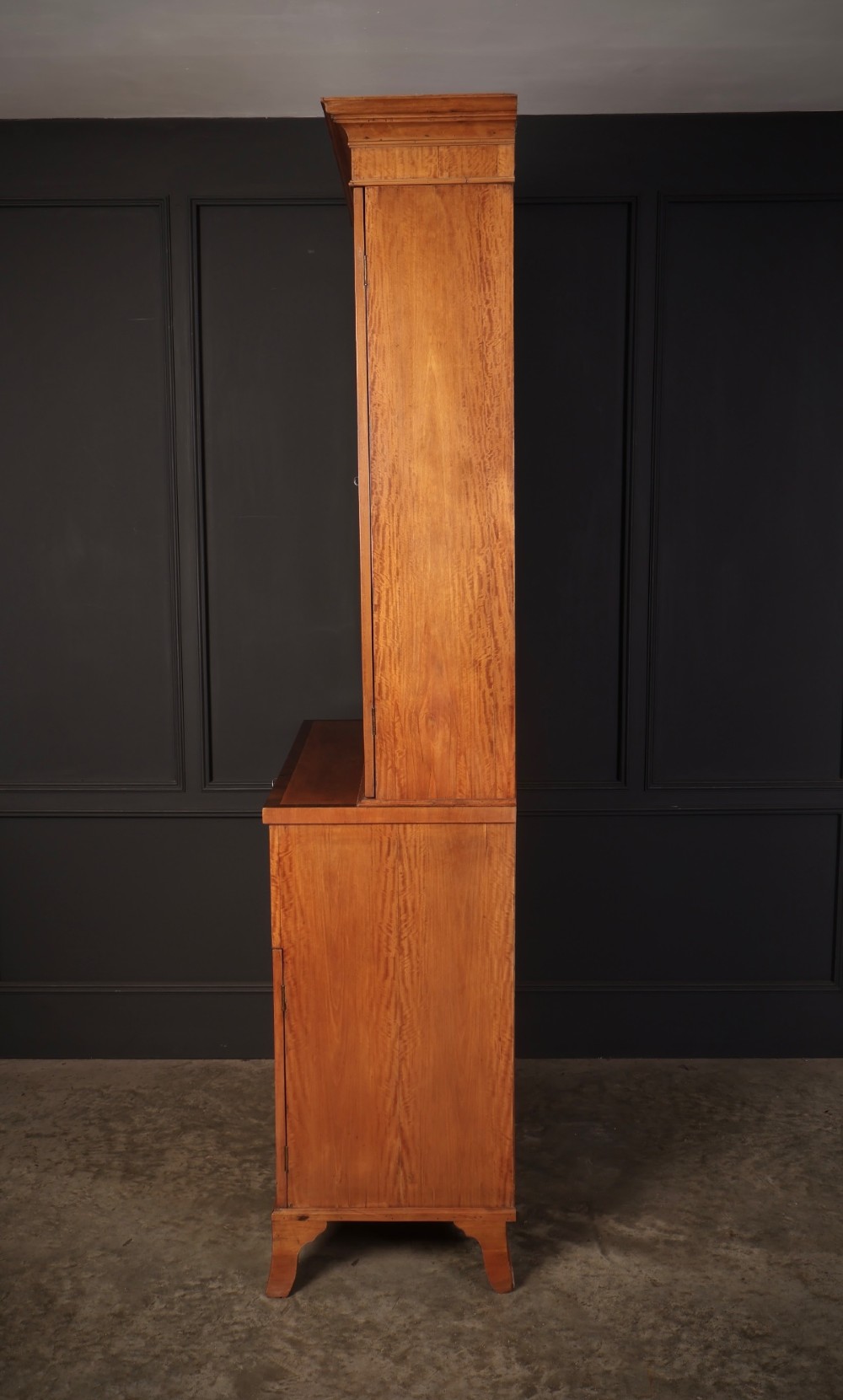 A tall Georgian satinwood secretaire bookcase featuring an upper glazed cabinet with geometric astragal bars, a fold-down desk drawer, and a lower double-door cupboard on splayed bracket feet. View X