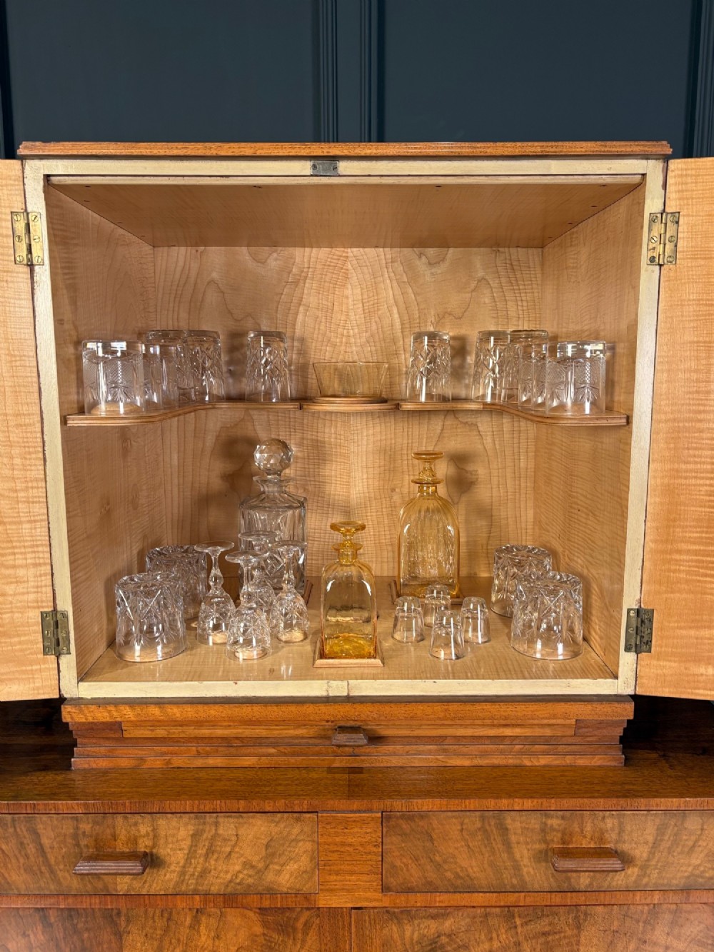 An Art Deco two-tiered cocktail cabinet in figured walnut veneer featuring double doors and geometric paneling. View VI