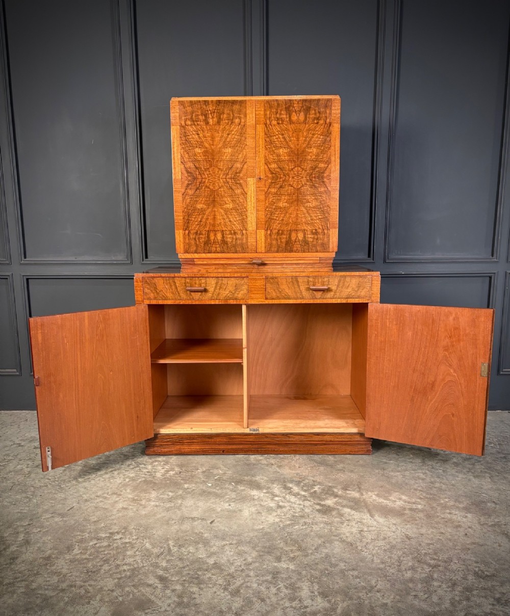 An Art Deco two-tiered cocktail cabinet in figured walnut veneer featuring double doors and geometric paneling. View VIII