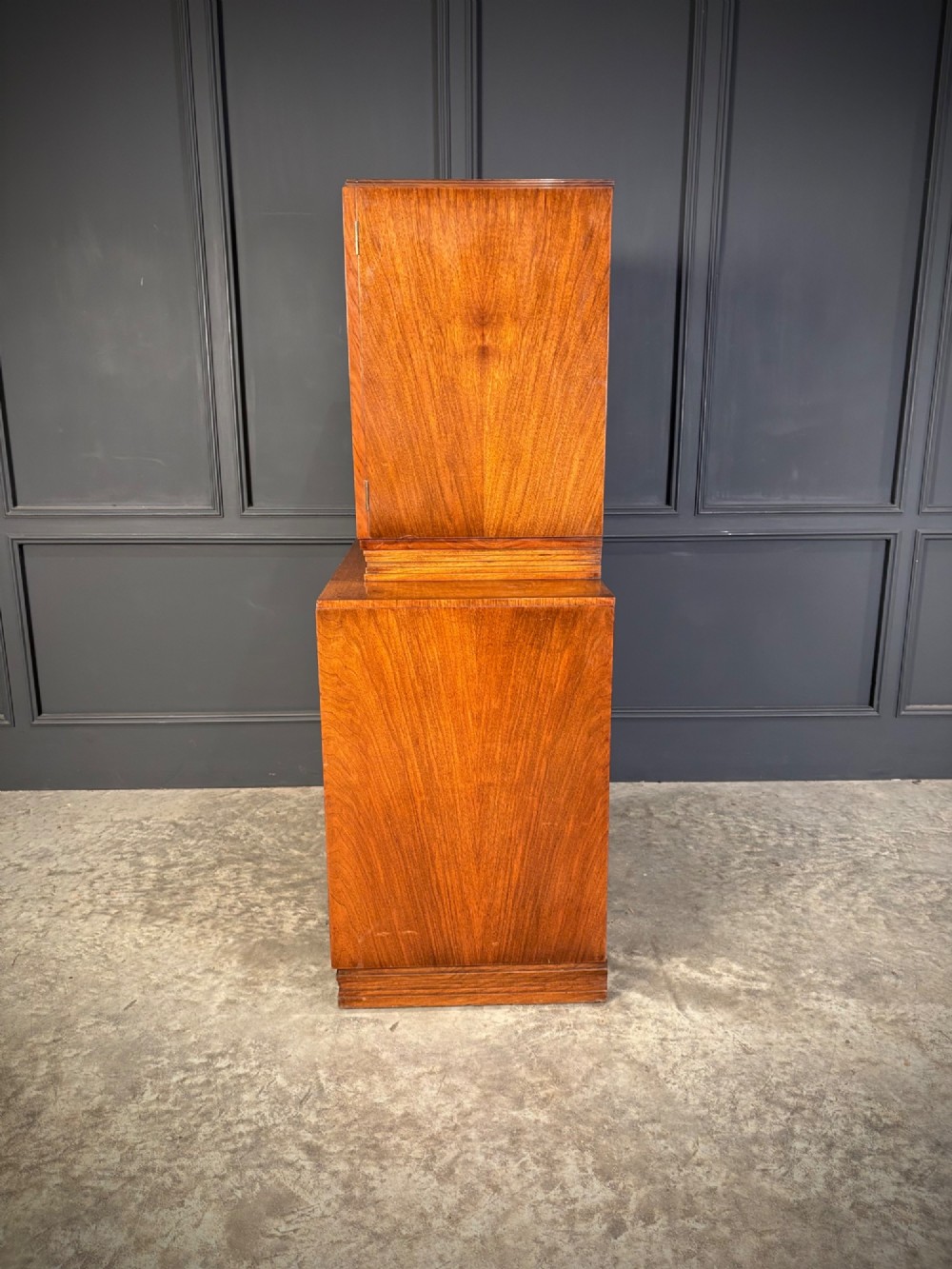 An Art Deco two-tiered cocktail cabinet in figured walnut veneer featuring double doors and geometric paneling. View XII