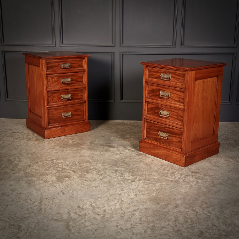 A matching pair of antique Victorian mahogany four-drawer bedside chests featuring plinth bases and brass card-pull handles.