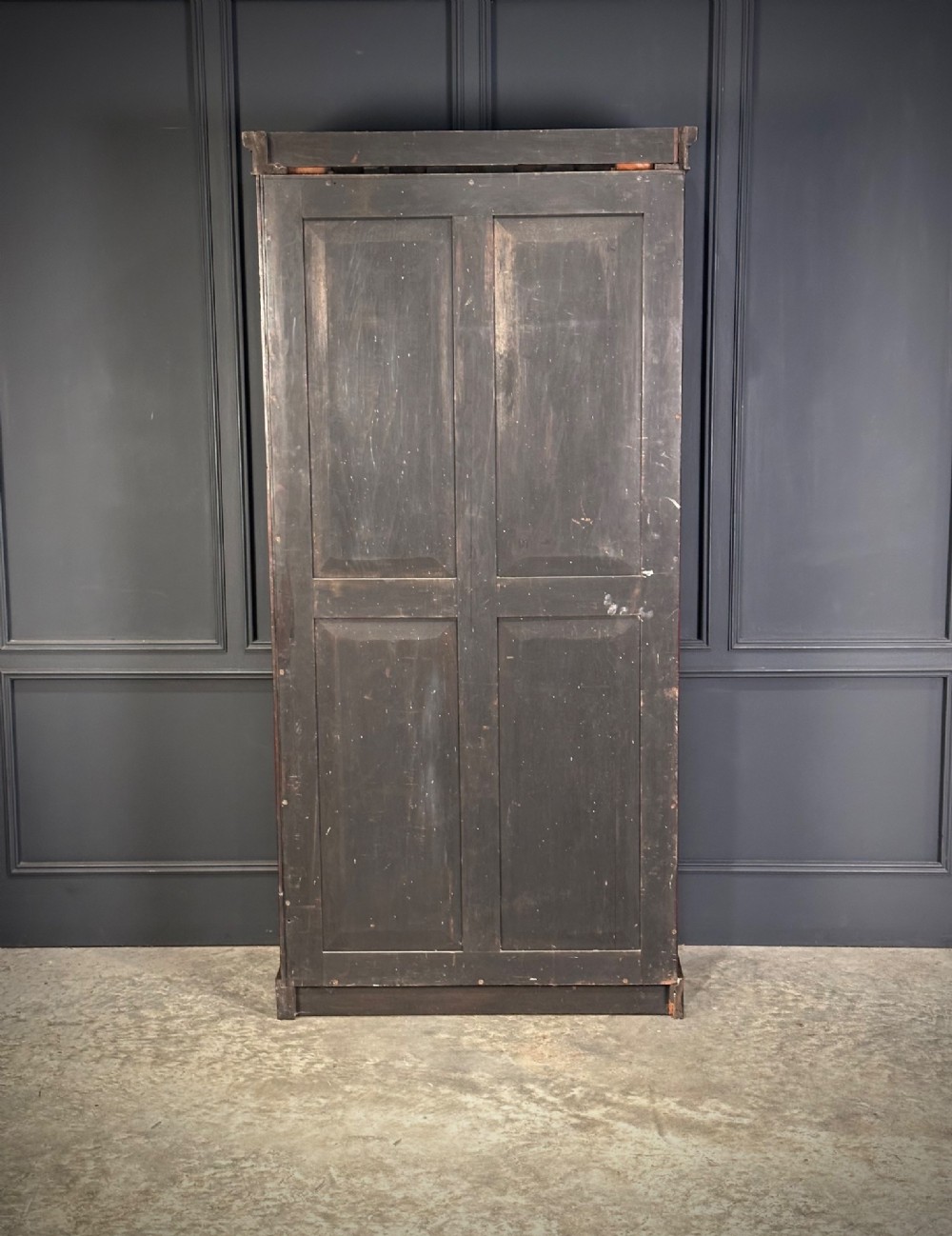 A tall Victorian rosewood bookcase featuring two upper arched glass doors and two lower glass doors on a flat plinth base. View VI