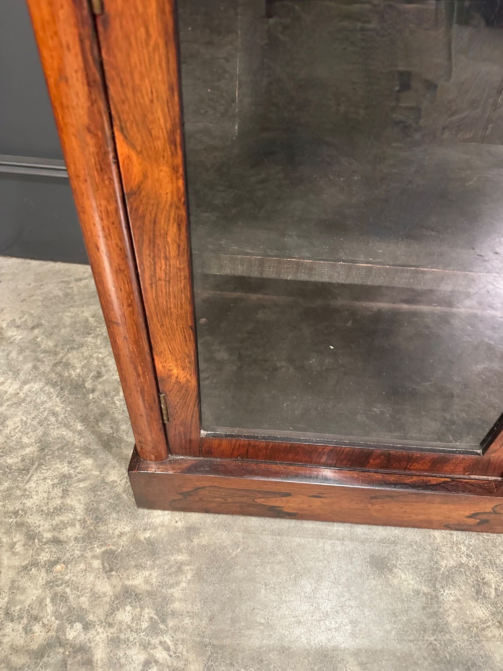 A tall Victorian rosewood bookcase featuring two upper arched glass doors and two lower glass doors on a flat plinth base. View VIII