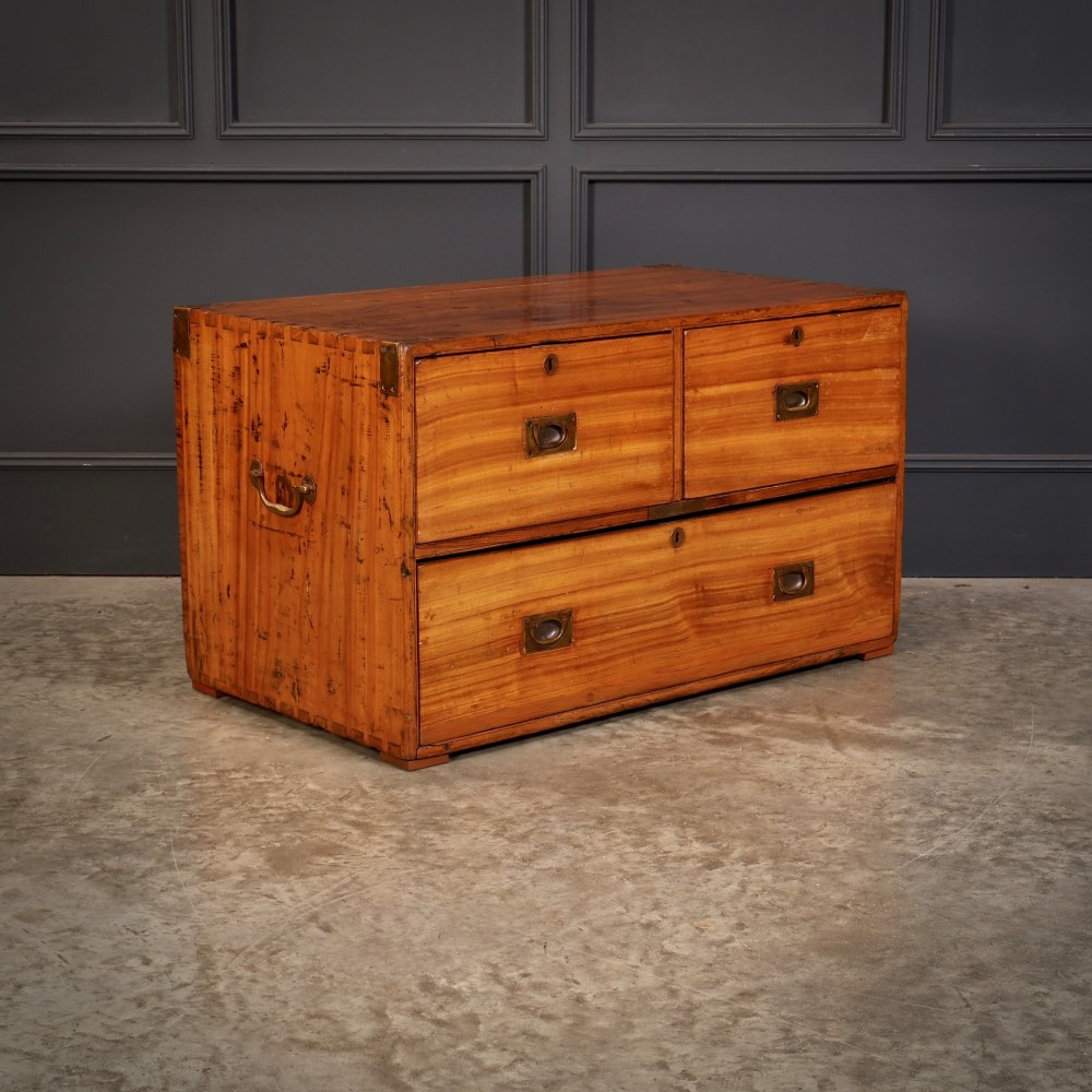 A low rectangular camphor wood campaign chest featuring three drawers with recessed brass handles, brass corner straps, and side carrying handles. View II