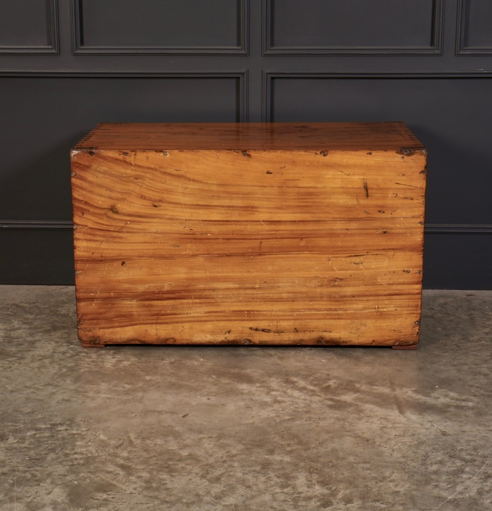 A low rectangular camphor wood campaign chest featuring three drawers with recessed brass handles, brass corner straps, and side carrying handles. View IX