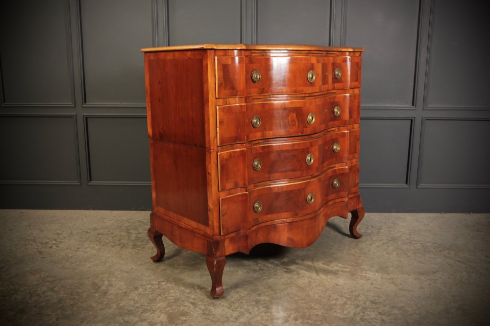 An antique walnut chest of drawers featuring a serpentine curved front, four graduated drawers with brass handles, and carved cabriole legs. View III