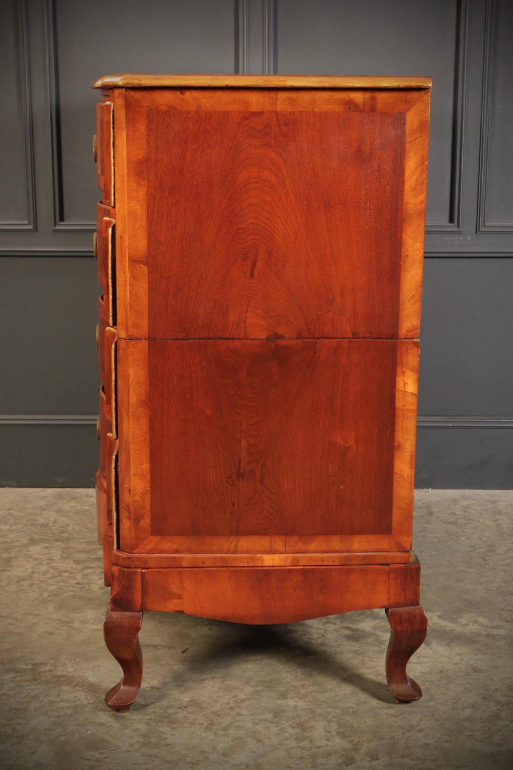 An antique walnut chest of drawers featuring a serpentine curved front, four graduated drawers with brass handles, and carved cabriole legs. View X