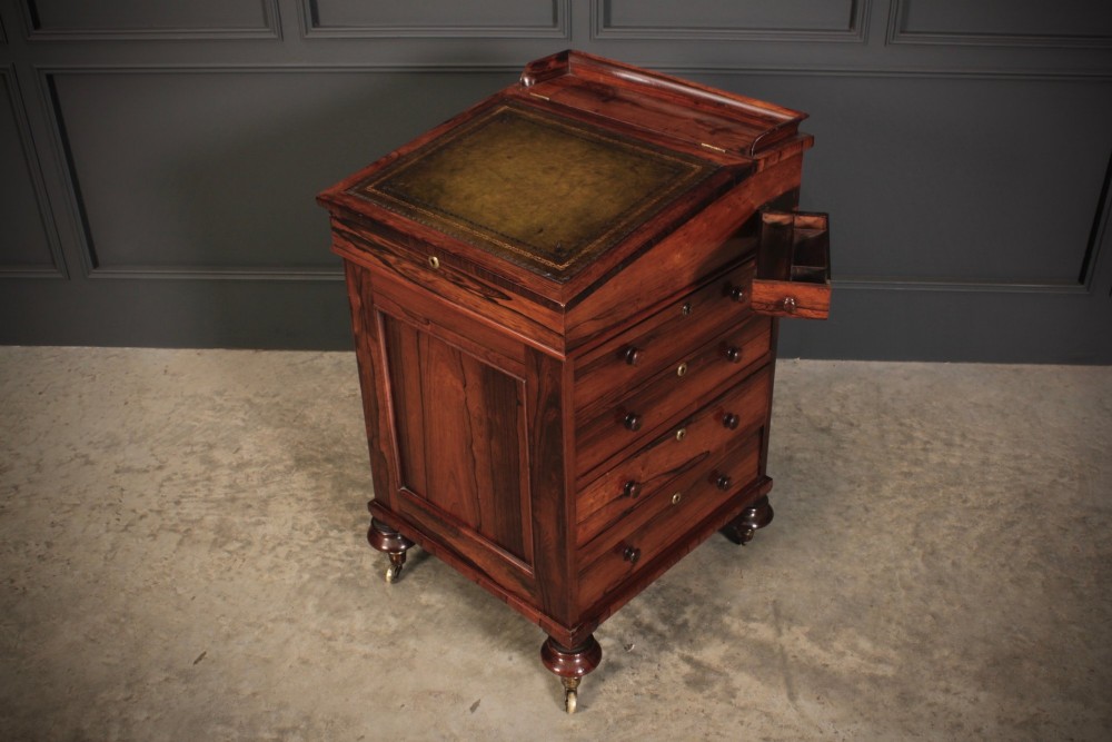 A William IV rosewood Davenport desk featuring a sloped leather writing surface, side drawers with turned knobs, and turned feet on castors. View VIII