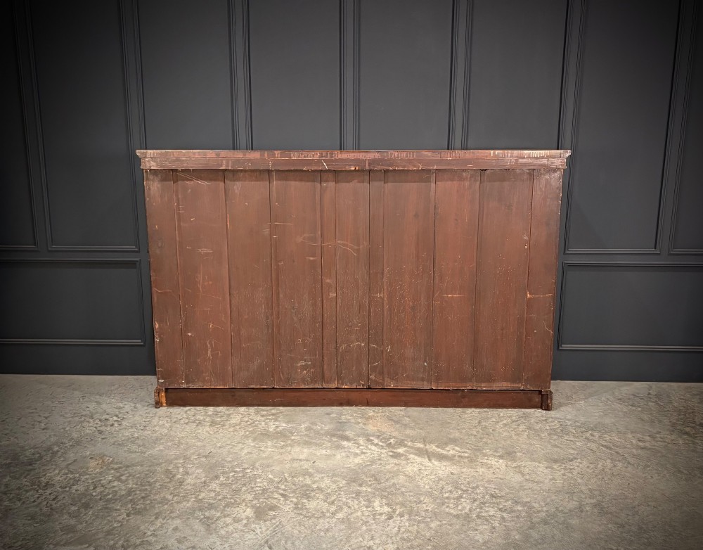 An antique Edwardian walnut breakfront bookcase with a central section featuring geometric panelled doors flanked by open adjustable shelving. View XI
