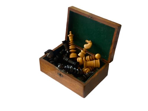 fig 1. A 19th-century Calvert pattern chess set featuring hand-turned boxwood and ebony chessmen displayed atop a polished wooden storage box with a keyhole.
