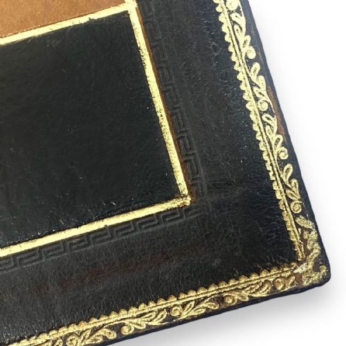 fig 1. An antique folding leather chess board with gold-tooled decorative borders and alternating tan and dark brown squares.