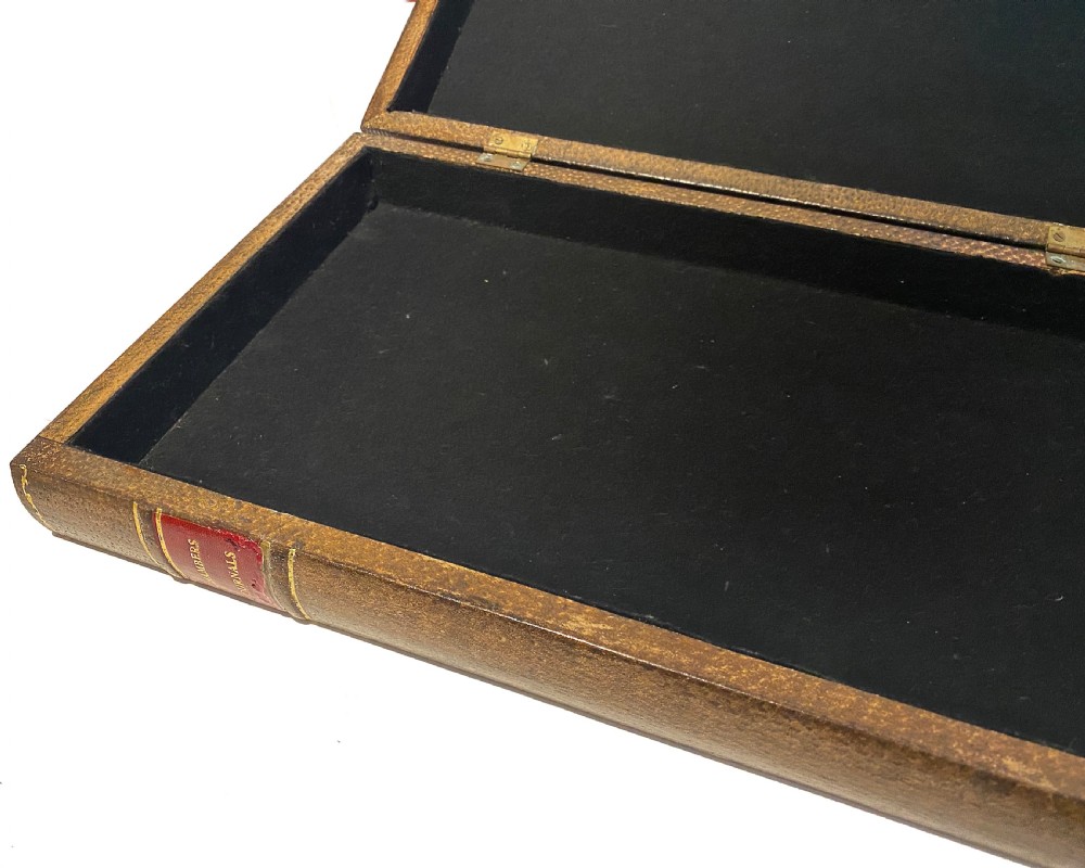 A brown leather folding chess board fashioned to resemble a vintage book with gold gilt tooling along the perimeter. View II