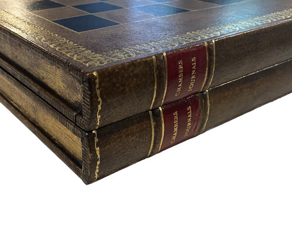 A brown leather folding chess board fashioned to resemble a vintage book with gold gilt tooling along the perimeter. View IV