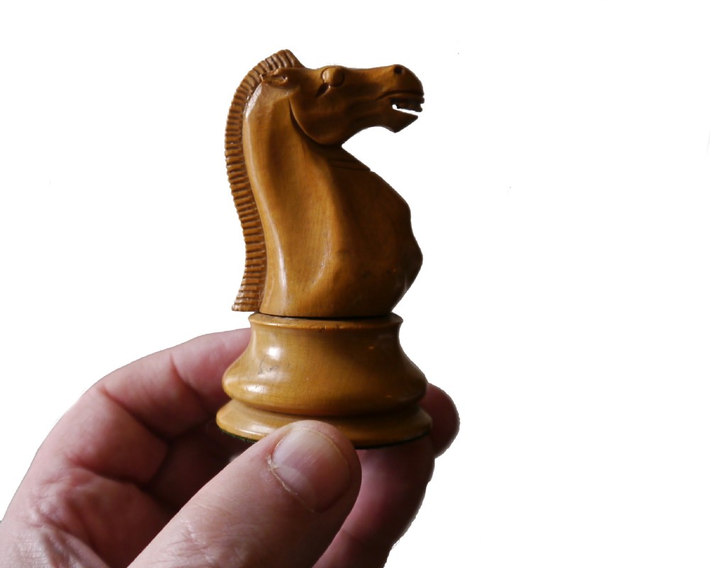A late 19th-century Staunton chess set featuring carved boxwood and ebony pieces displayed with a fitted wooden storage box. View III
