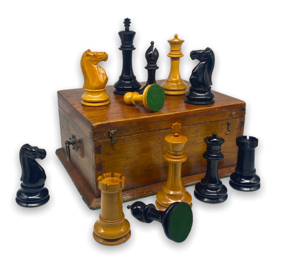 A late 19th-century Staunton chess set featuring carved boxwood and ebony pieces displayed with a fitted wooden storage box.